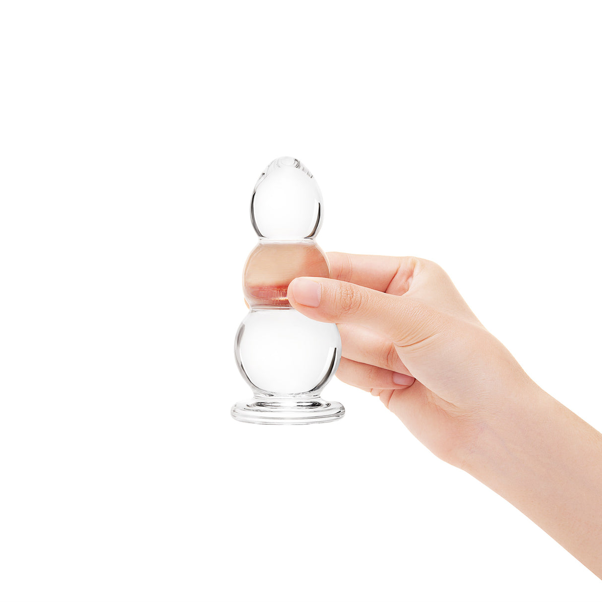 A hand holding the plug to show its compact overall size and the distinct three-bulb shape.