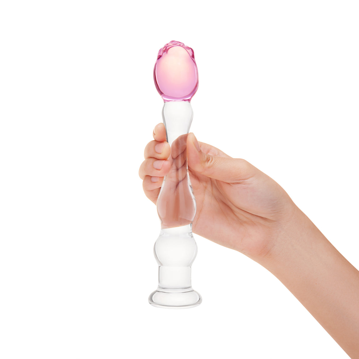 Hand holding a textured glass dildo, featuring gentle ripples, a tapered tip, and a secure pink rosebud base on a white background