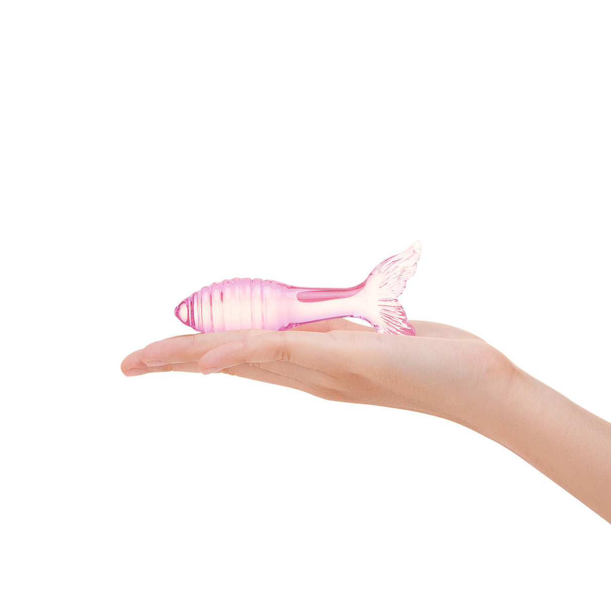 A hand holding the 4.75-inch plug to show the delicate scale and the light
filtering through the pink glass.