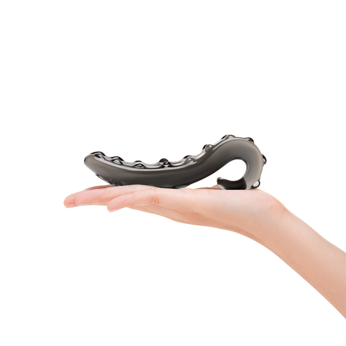 Hand holding a Black Nubbed G-Spot Glass Dildo on a white background