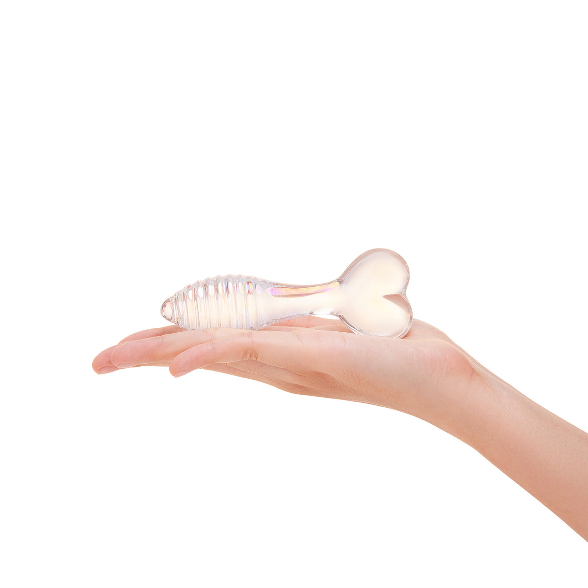 Hand holding a wRibbed Shaft Glass Anal Plug with a heart shaped base against a white background