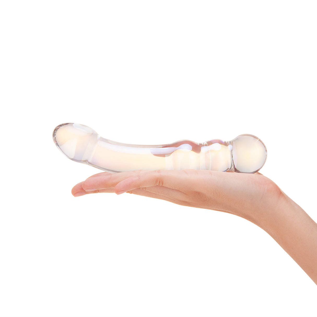 Hand holding a dual-ended glass dildo with teardrop and beaded ends on a white background