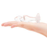 3.35" Sweet Twist Butt Plug - Medium  In-palm/Scale: Clear glass twist plug held in hand to demonstrate the contoured grip and overall size.