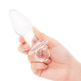 4.95" Crystal Twinkle Butt Plug Crystal In-Hand/Scale: Clear glass plug held in hand to demonstrate its satisfying, full feel and dazzling scale.

