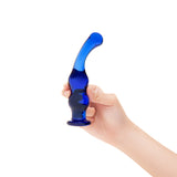 Hand holding a blue curved dildo against a white background