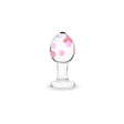 Glass anal plug with flat base with pink polka dots on a white background