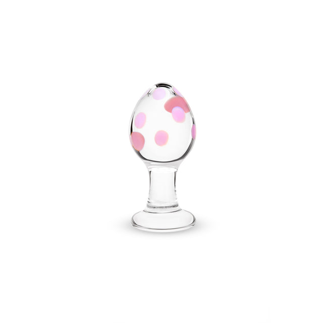 Glass anal plug with flat base with pink polka dots on a white background