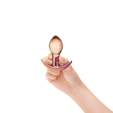 Hand holding a  Bulbous Glass Anal Toy with a reflective surface on a white background
