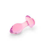 Pink heart anal glass plug on a white background