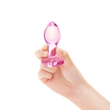 Hand holding a pink  Heart Base Glass Toy  product against a white background