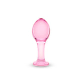 Pink glass anal plug on a white background