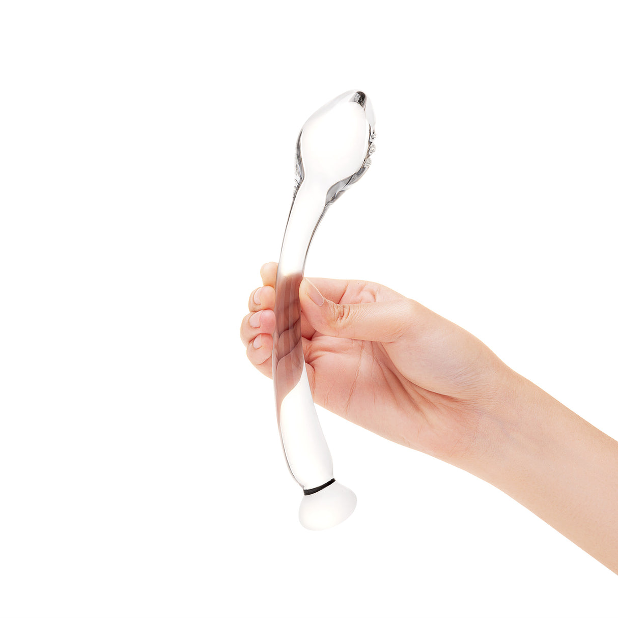 Clear glass dildo held by a hand on a white background