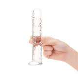 Clear glass Long Textured Glass Dildo held by a hand on a white background
