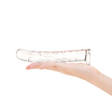 Clear glass Long Textured Glass Dildo held in a hand against a white background