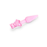 Pink glass anal plug with a bear-shaped base and tapered smooth tip on a white background