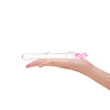 Hand holding a Clear beaded glass dildo featuing a tapered tip and cute pink bear base on a white background