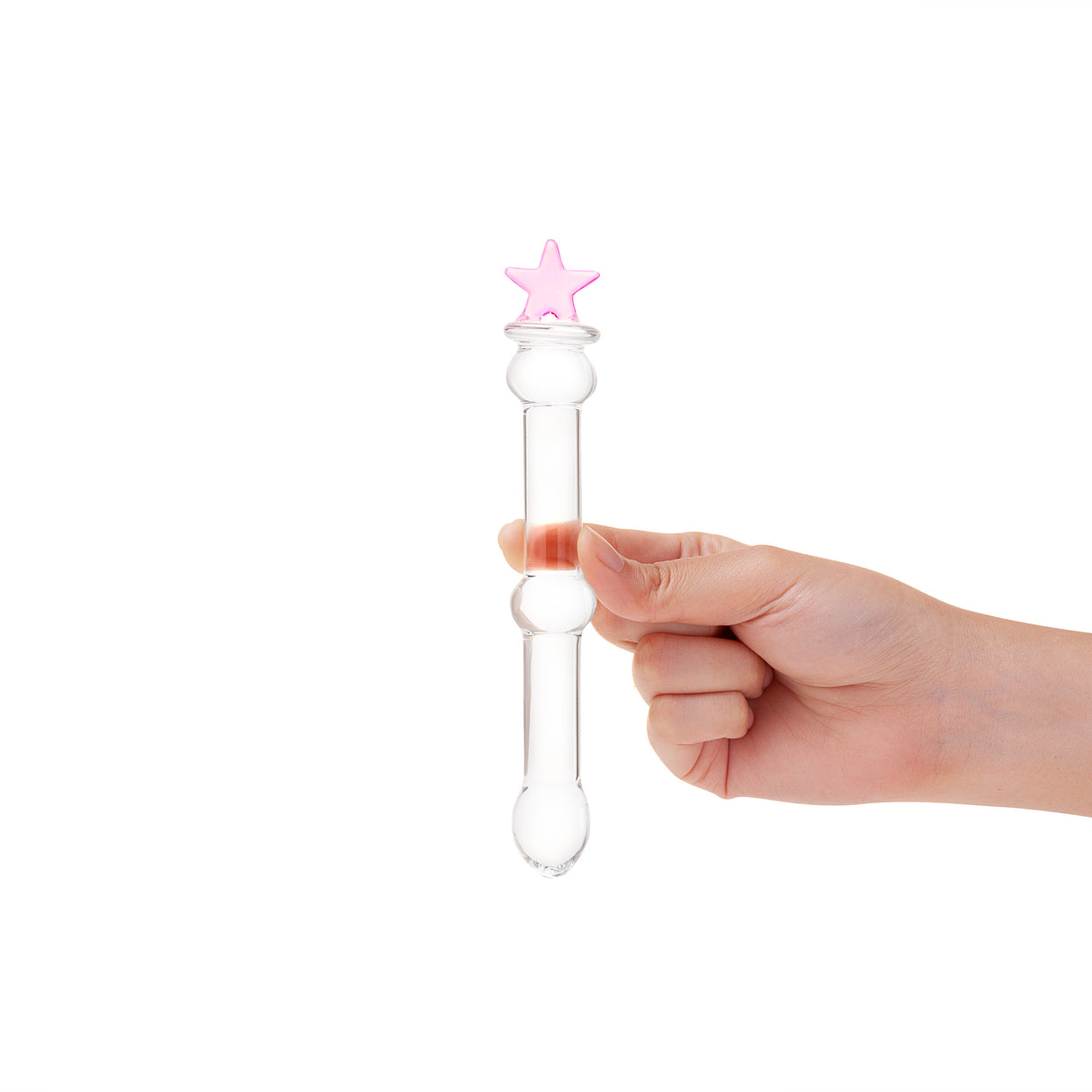 Hand holding a beaded glass dildo featuring a pink star base and mid-shaft bead on a white background
