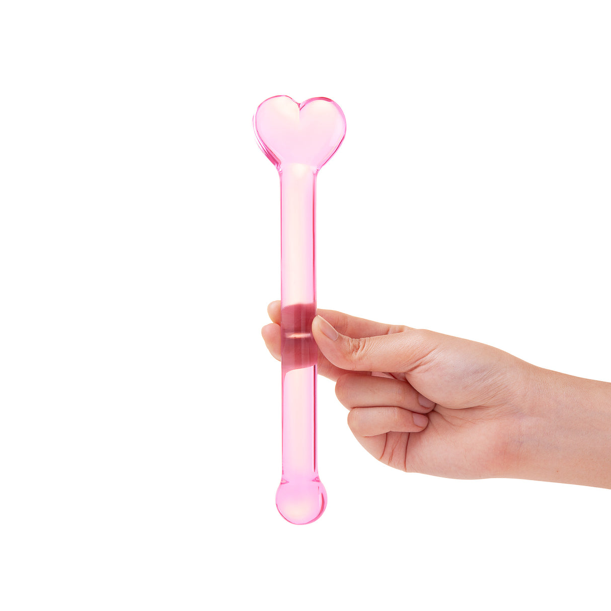 Hand holding a Pink glass dildo with a heart base and round tip against a white background