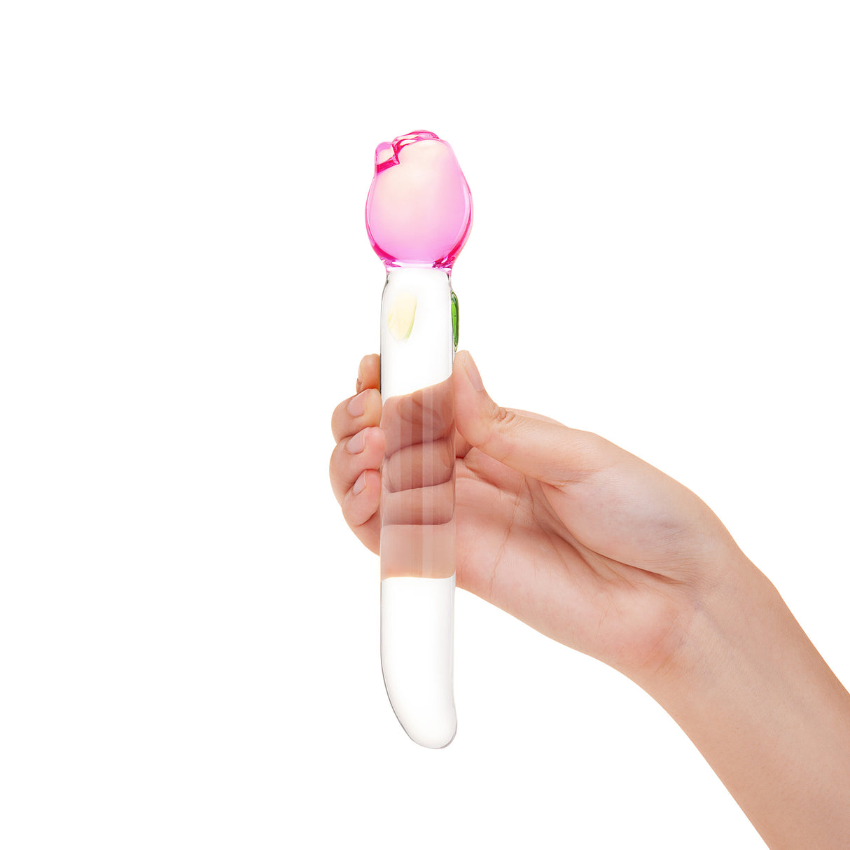 Hand holding a glass floral dildo—sleek shaft, tapered tip, and a secure pink tulip base on a white background