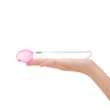 glass floral dildo—sleek shaft, tapered tip, and a secure pink tulip base held in a hand on a white background