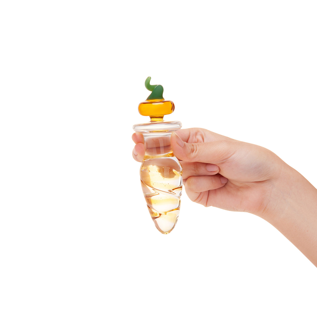 Hand holding Glass anal plug featuring a rippled shaft and a jack-o-lantern pumpkin-shaped base on a white background