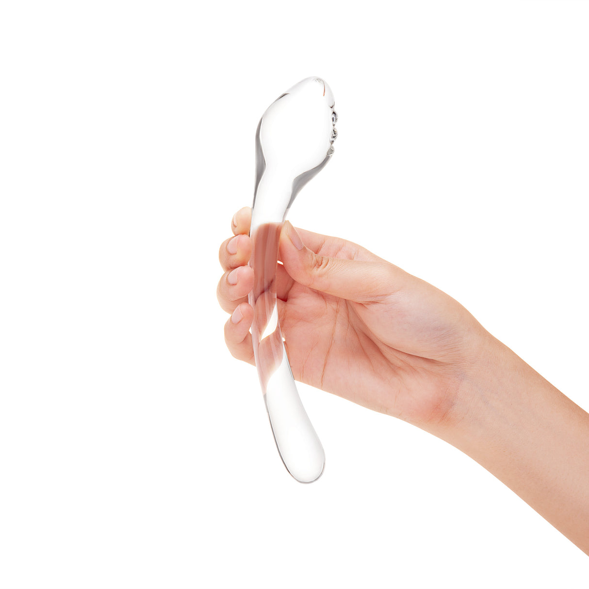Hand holding a Clear G-Spot Curved Glass Dildo with teardrop-shaped textured tip against a white background