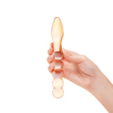 Hand holding a Dual-Ended Beaded Glass Dildo - smooth tapered end and a beaded shaft against a white background