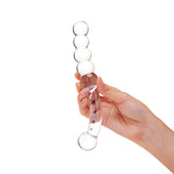 Hand holding a Dual-Ended Glass Dildo featuring blue accentsw with beaded ends and round bulb tip on a white background