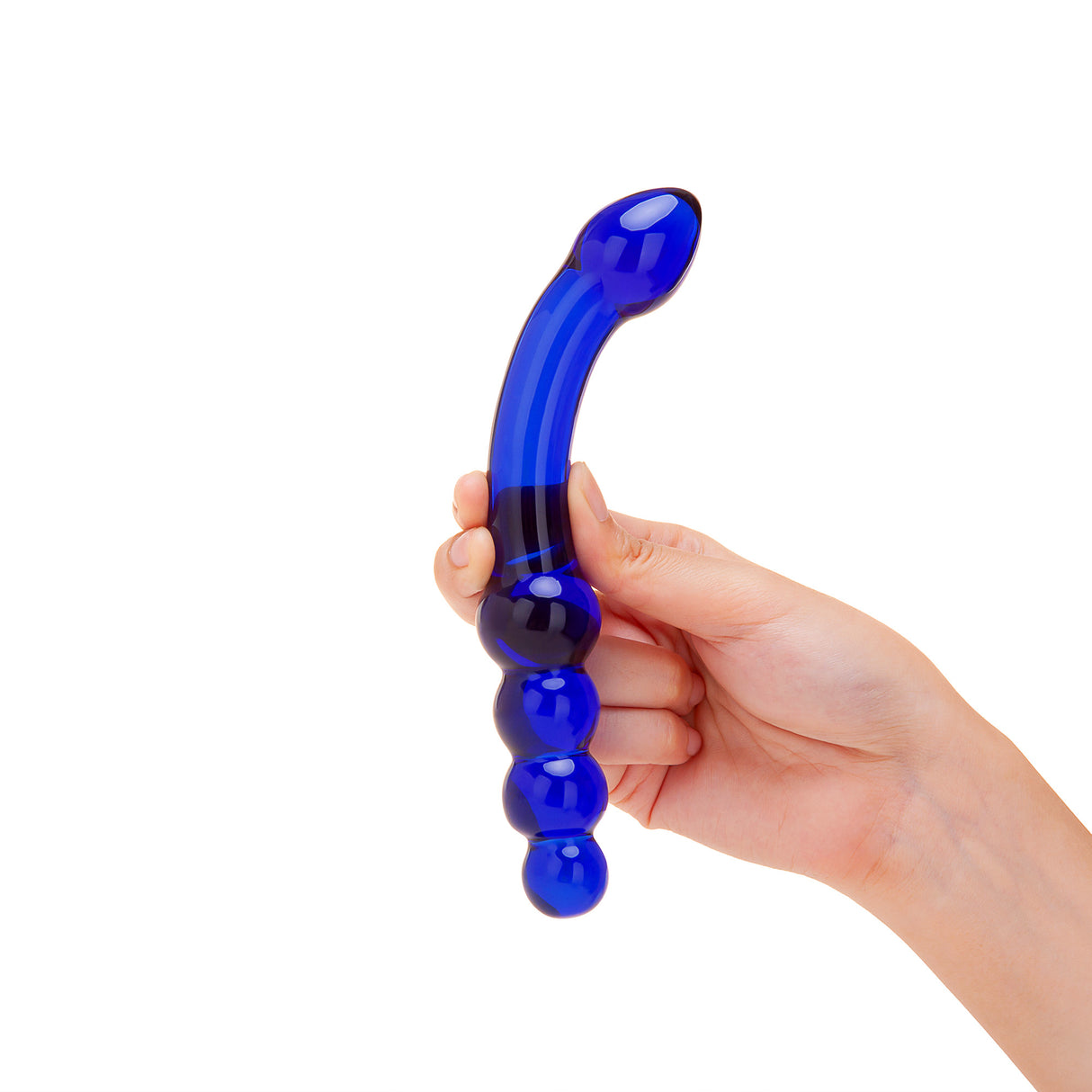 Hand holding a blue dual-ended glass curved dildo with graduated beads and tapered tip against a white background