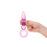 Hand holding a Pink glass anal plug with beaded shaft, tapered tip and ring baseagainst a white background
