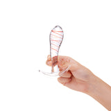 Hand holding a Tapered Glass Anal Plug with red stripes on a white background
