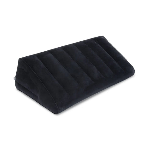 Black flocked b-Vibe Essentials inflatable sex position ramp fully inflated on a bed.