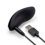 Black vibrator showing the USB charging cable with a magnetic connector on a white background