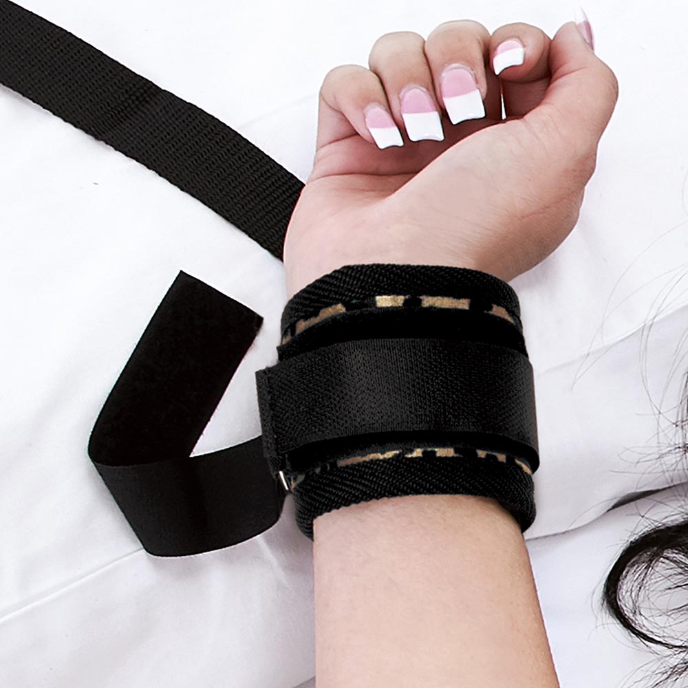 Model with wrist cuffed with the Lux Fetish 7-Piece Bed Spreader in Leopard Pattern